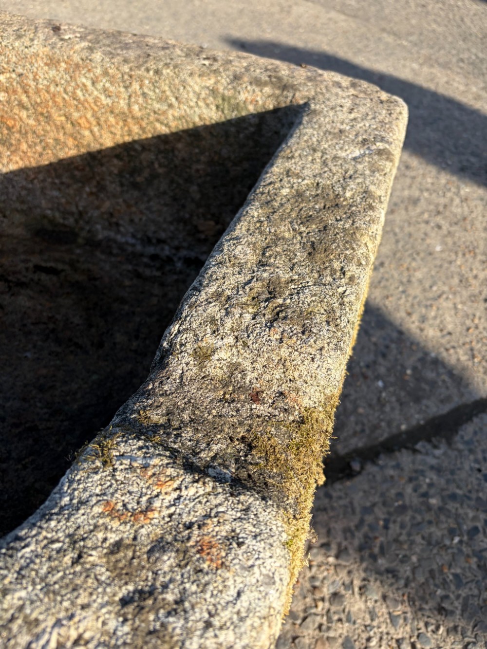A heavy rectangular antique Cornish granite trough featuring a hand-chiselled rough stone exterior and carved basin. View IV