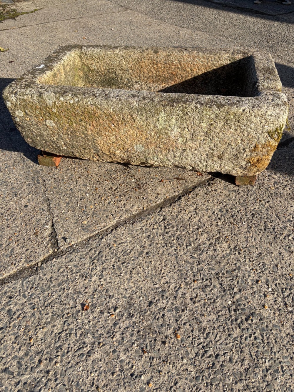 A heavy rectangular antique Cornish granite trough featuring a hand-chiselled rough stone exterior and carved basin. View V