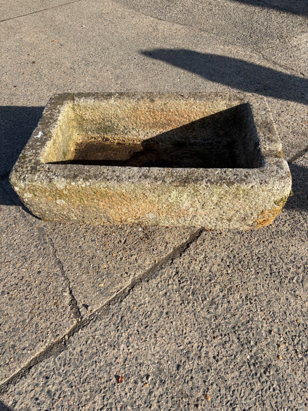 A heavy rectangular antique Cornish granite trough featuring a hand-chiselled rough stone exterior and carved basin. View VI