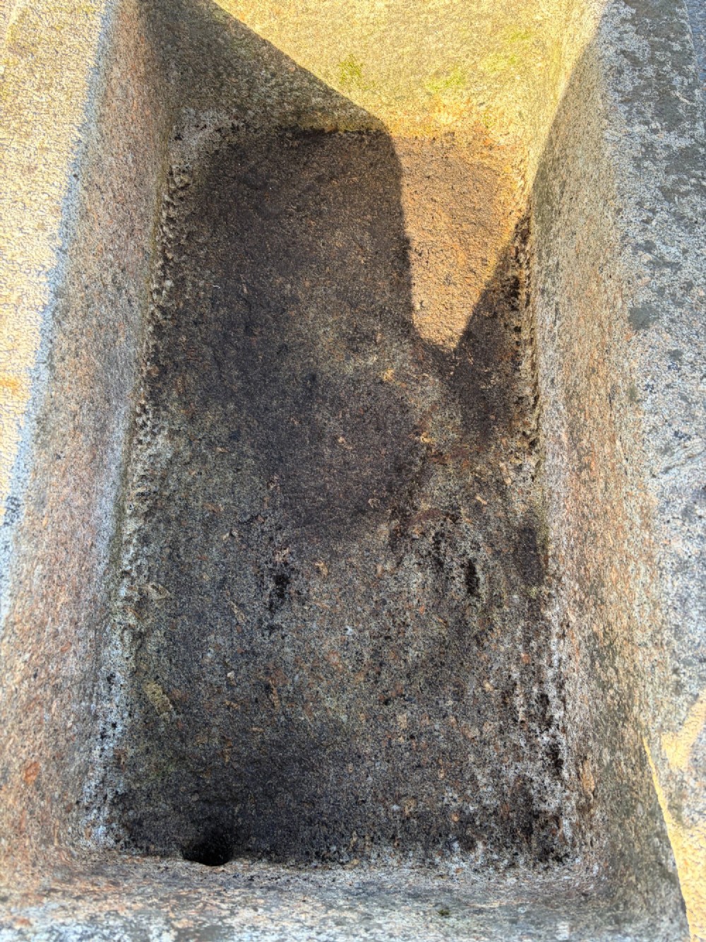 A heavy rectangular antique Cornish granite trough featuring a hand-chiselled rough stone exterior and carved basin. View IX
