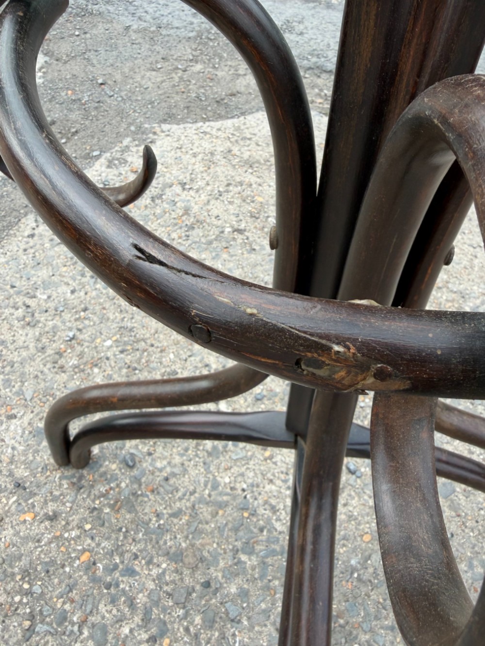 A dark brown bentwood coat stand with curved upper hooks, central accessory loops, a turned finial, and four splayed legs. View V
