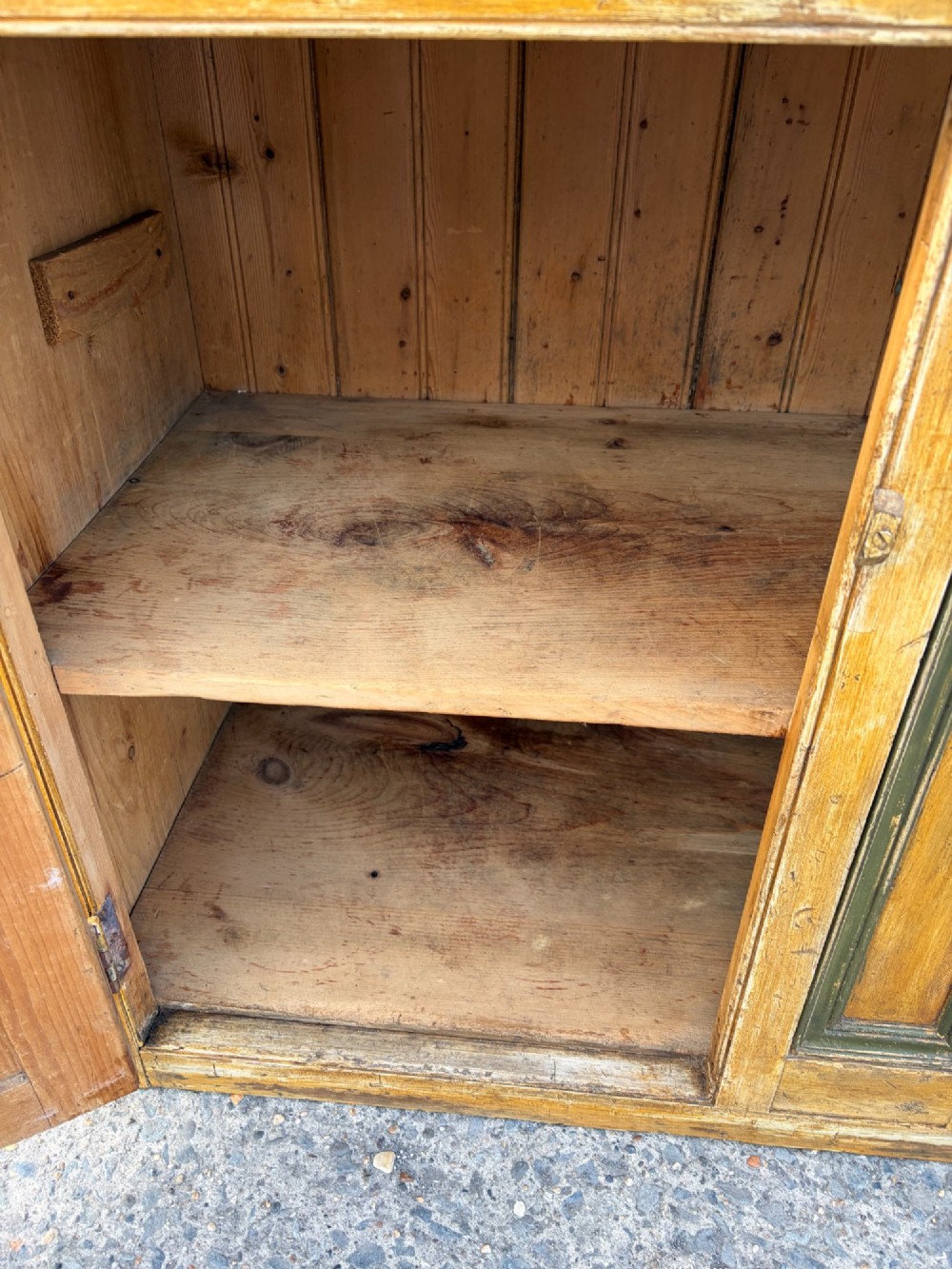 A late Victorian pine dresser base featuring a distressed ochre and green painted finish, three upper drawers, and recessed panel cupboard doors with wooden handles. View VII
