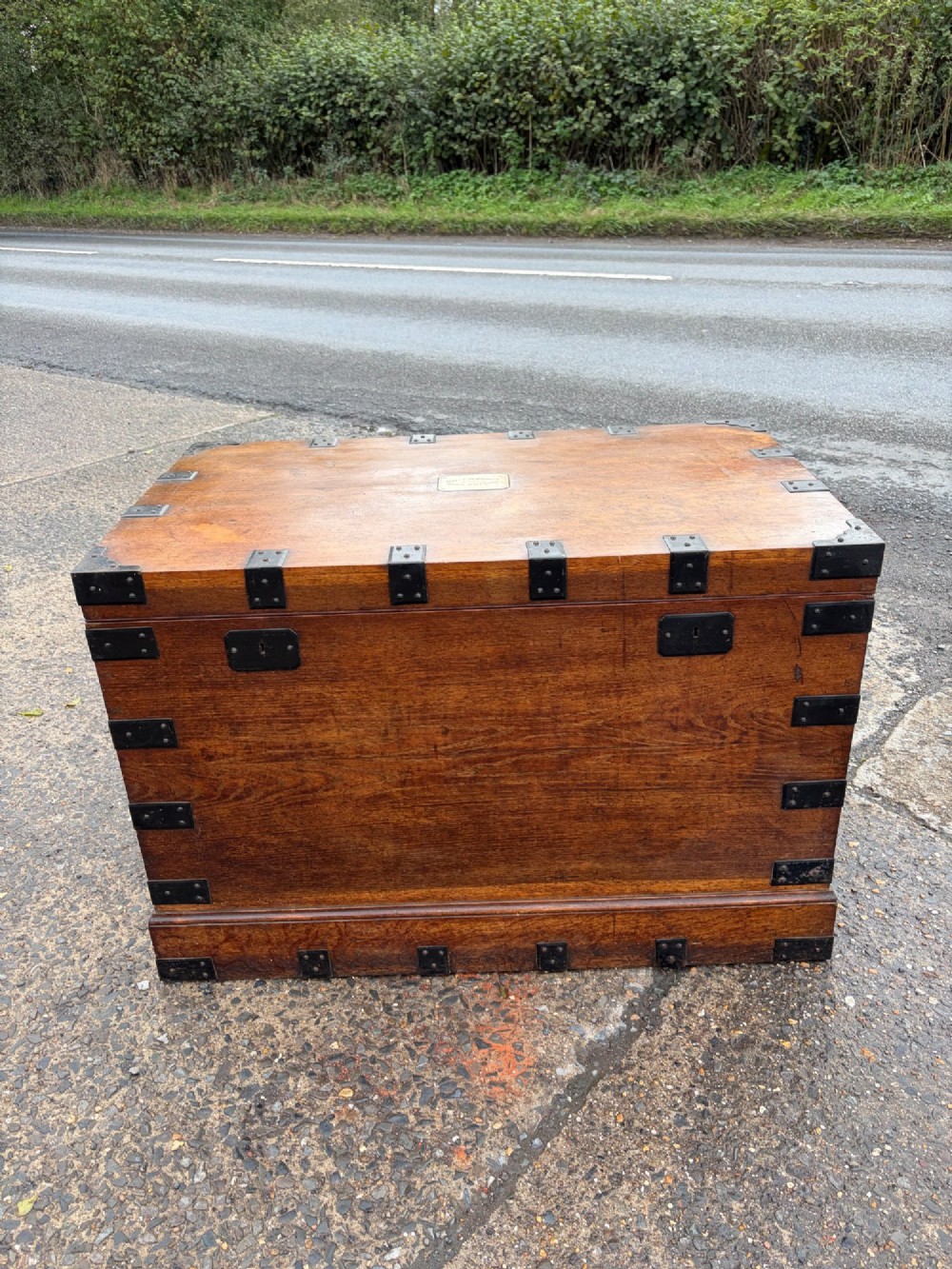 A rectangular Victorian oak silver chest with dark iron corner brackets and a brass plate set into the top lid.