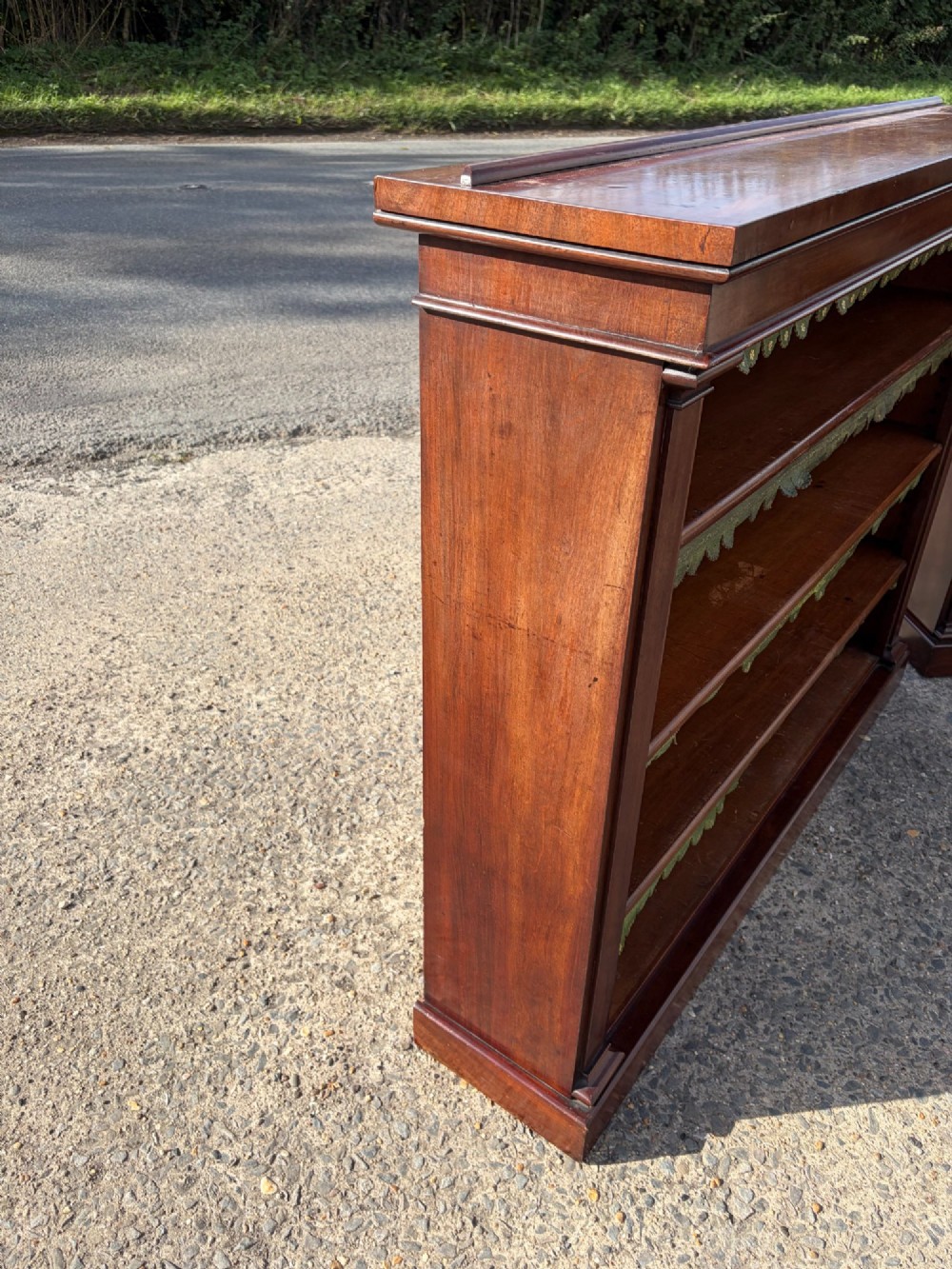 A matching pair of low, open-front early Victorian mahogany bookcases featuring green scalloped leather dust flaps along the shelf edges. View VII