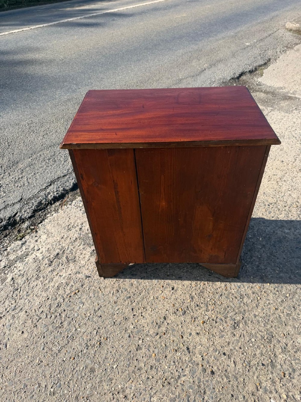 An antique Georgian mahogany bachelors chest featuring four graduated drawers with brass handles, a pull-out brushing slide, and bracket feet. View III