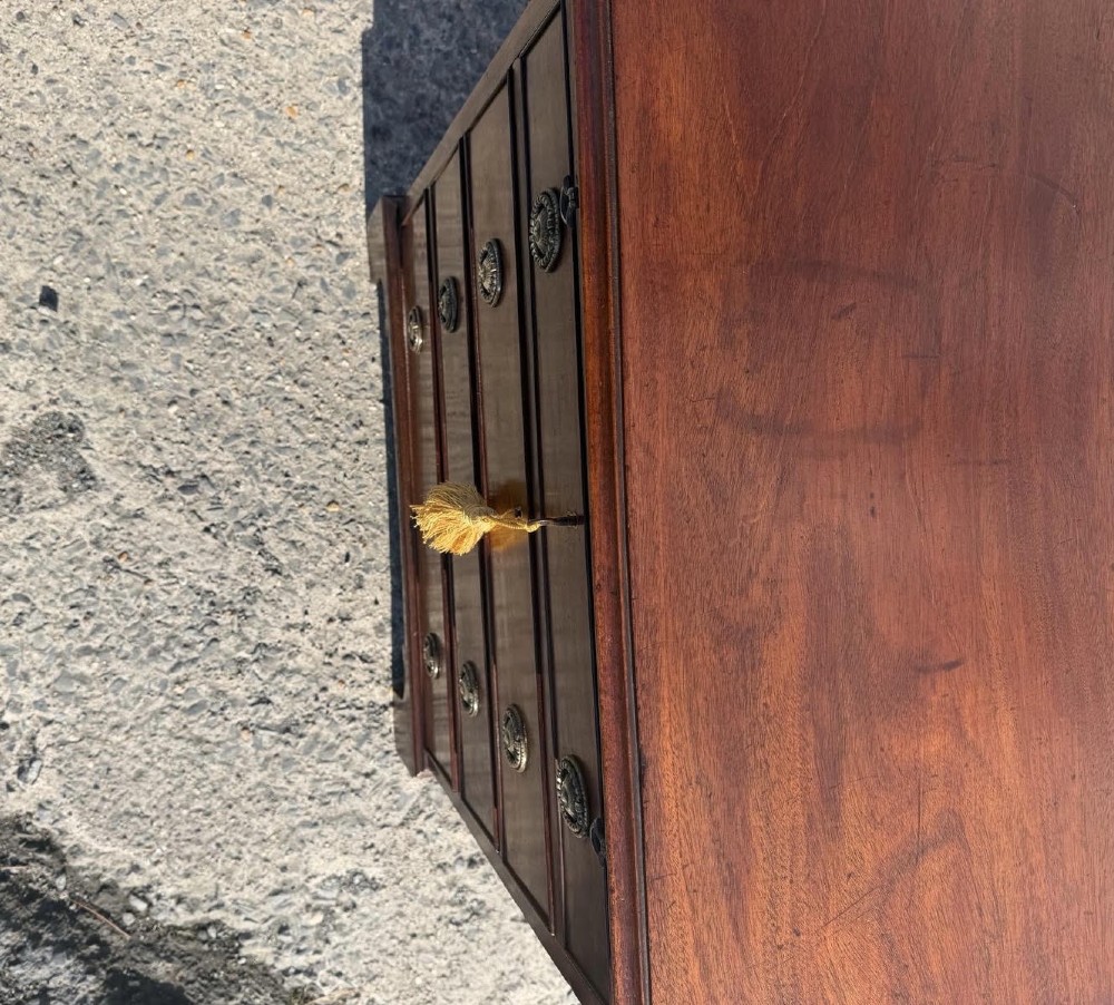 An antique Georgian mahogany bachelors chest featuring four graduated drawers with brass handles, a pull-out brushing slide, and bracket feet. View VI