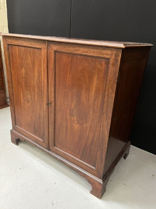 fig 1. A Georgian mahogany two-door housekeepers cupboard with panelled fronts and bracket feet.