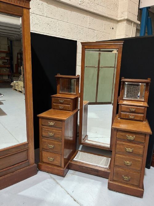 fig 1. A Victorian mahogany twin pedestal dressing table featuring a tall central cheval mirror flanked by side drawer units and smaller elevated mirrors.