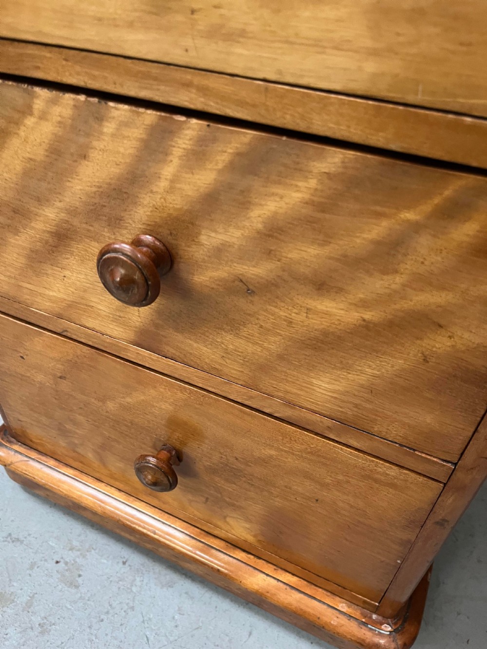A Victorian satin birch pedestal writing desk featuring eight drawers with turned wooden knobs and an arched central kneehole. View VII