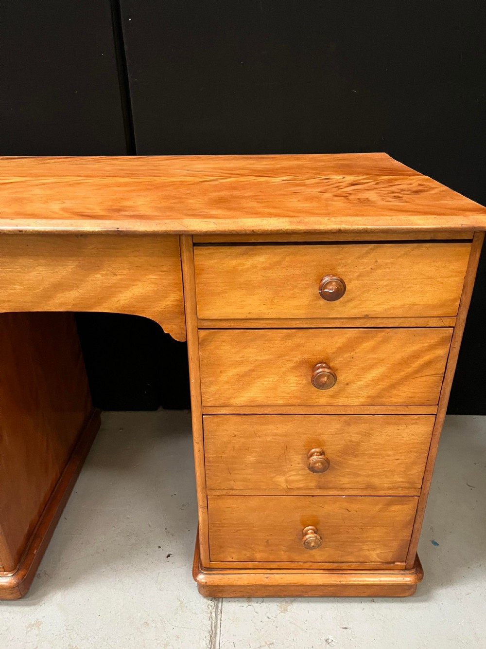 A Victorian satin birch pedestal writing desk featuring eight drawers with turned wooden knobs and an arched central kneehole. View IX
