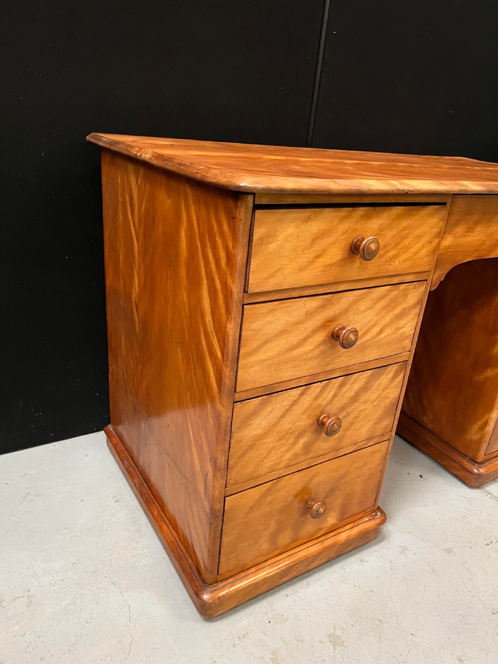 A Victorian satin birch pedestal writing desk featuring eight drawers with turned wooden knobs and an arched central kneehole. View XII