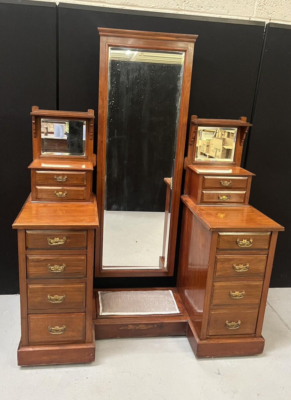 A Victorian mahogany twin pedestal dressing table featuring a tall central cheval mirror flanked by side drawer units and smaller elevated mirrors.