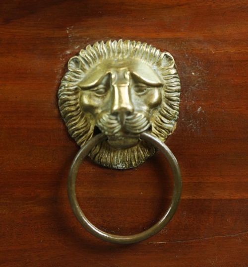 An early nineteenth-century French Empire mahogany commode featuring three drawers with brass lion-mask ring handles, gilt female caryatid mounts at the upper corners, a dark veined marble top, and sculpted paw feet. View III