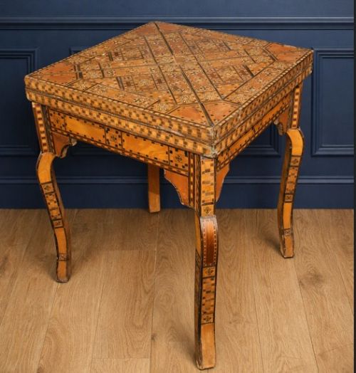fig 2. A square 19th-century Damascus games table featuring geometric wood marquetry inlay, an envelope-style folding top with a central chessboard, and cabriole legs.