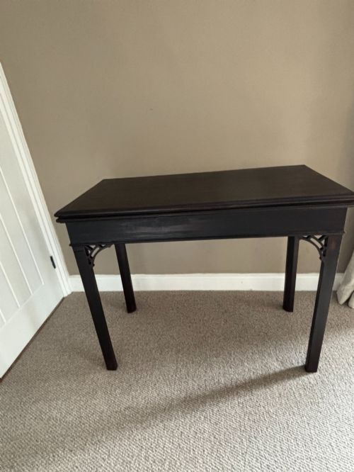 fig 1. An 18th-century Chippendale mahogany card table with a rectangular fold-over top, pierced fretwork corner brackets, and straight square legs.
