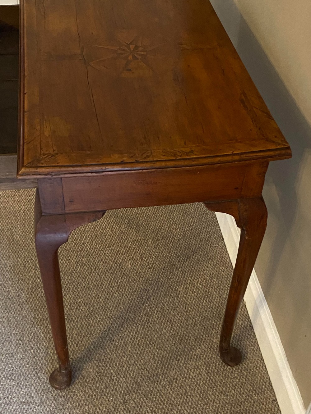 A Georgian fruitwood side table featuring cabriole legs with pad feet, a single drawer with brass handles, and a central star compass inlay on the tabletop. View II