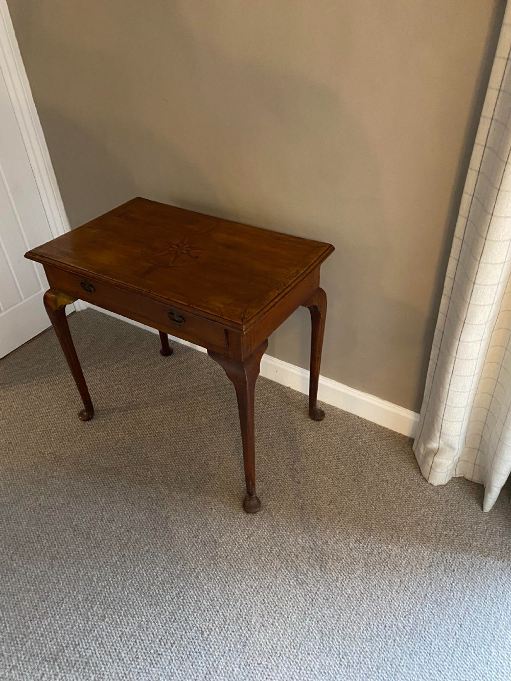 A Georgian fruitwood side table featuring cabriole legs with pad feet, a single drawer with brass handles, and a central star compass inlay on the tabletop. View V