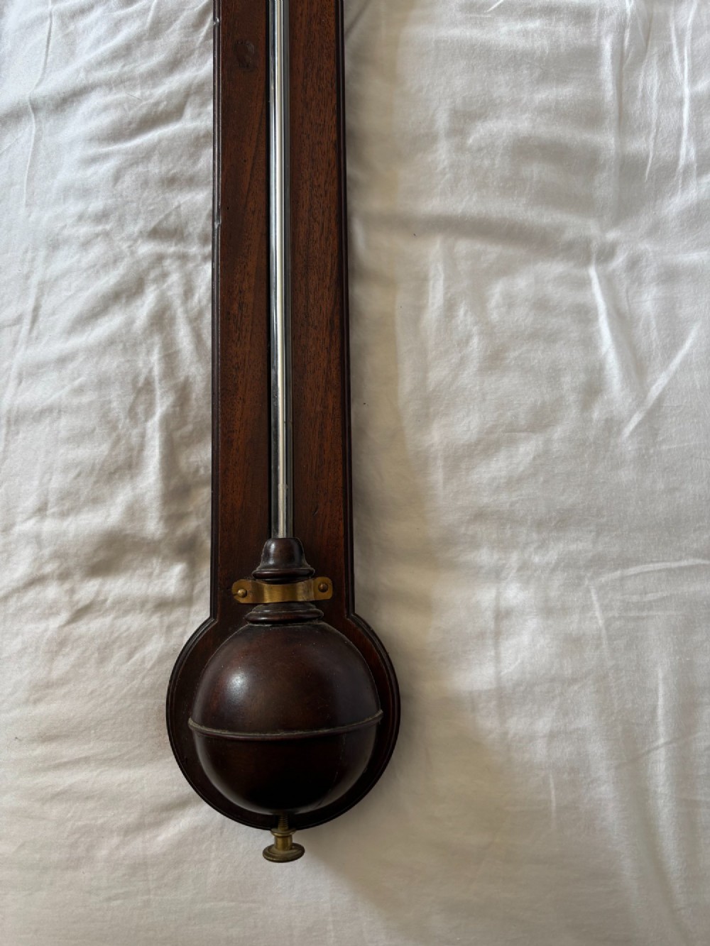 A late 18th-century Georgian mahogany stick barometer featuring a broken pediment top with a brass finial and an engraved silvered brass dial plate. View II
