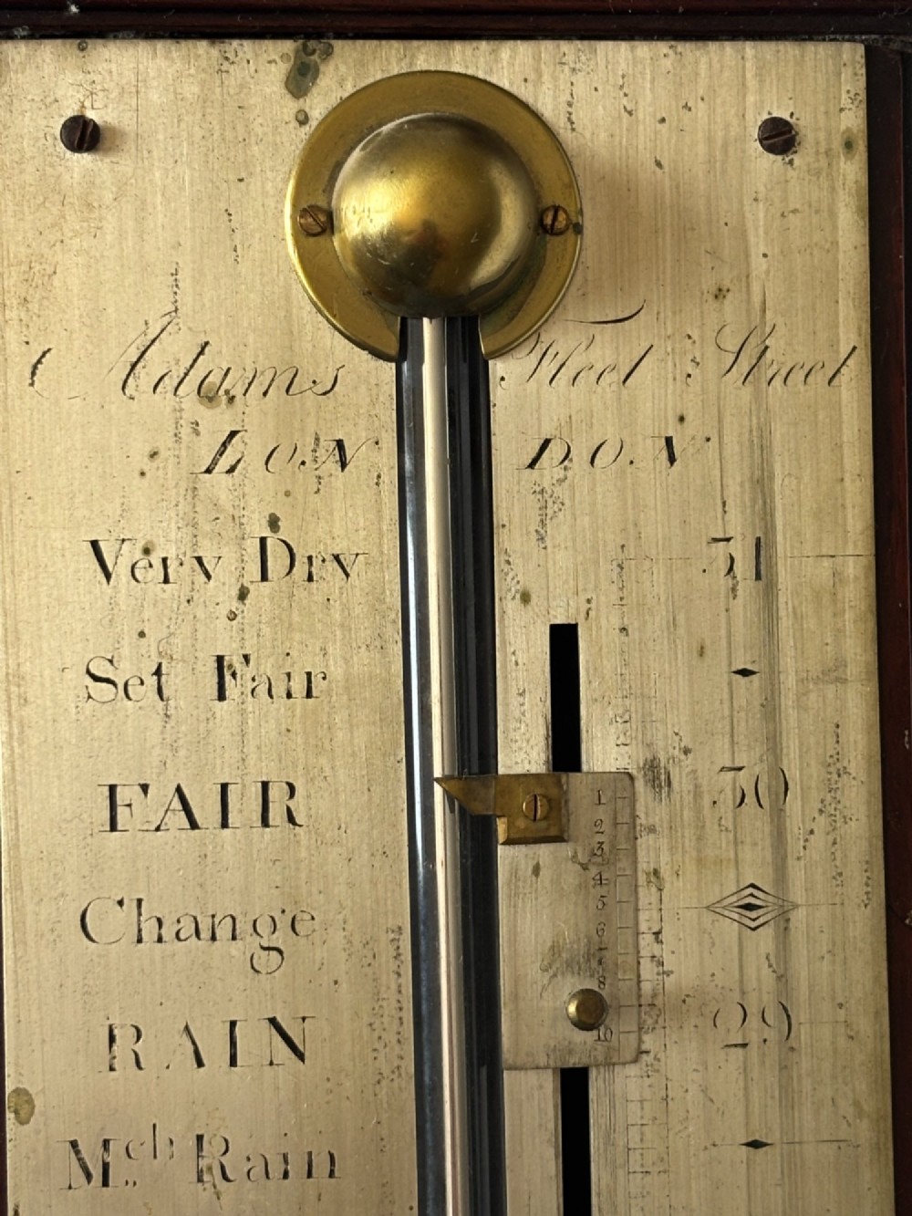 A late 18th-century Georgian mahogany stick barometer featuring a broken pediment top with a brass finial and an engraved silvered brass dial plate. View III