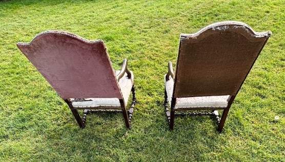 A pair of early 18th-century French walnut open armchairs with turned stretchers and worn floral tapestry upholstery. View II