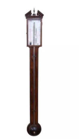 A Regency mahogany stick barometer featuring a pediment top, central mercury tube, thermometer, and an engraved silvered brass scale signed P. Caminada Taunton. View II