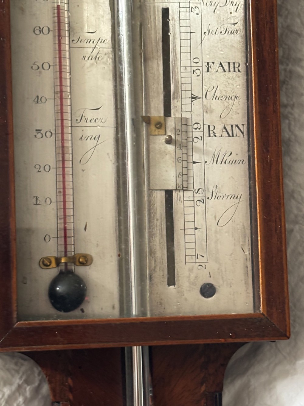 A Regency mahogany stick barometer featuring a pediment top, central mercury tube, thermometer, and an engraved silvered brass scale signed P. Caminada Taunton. View V