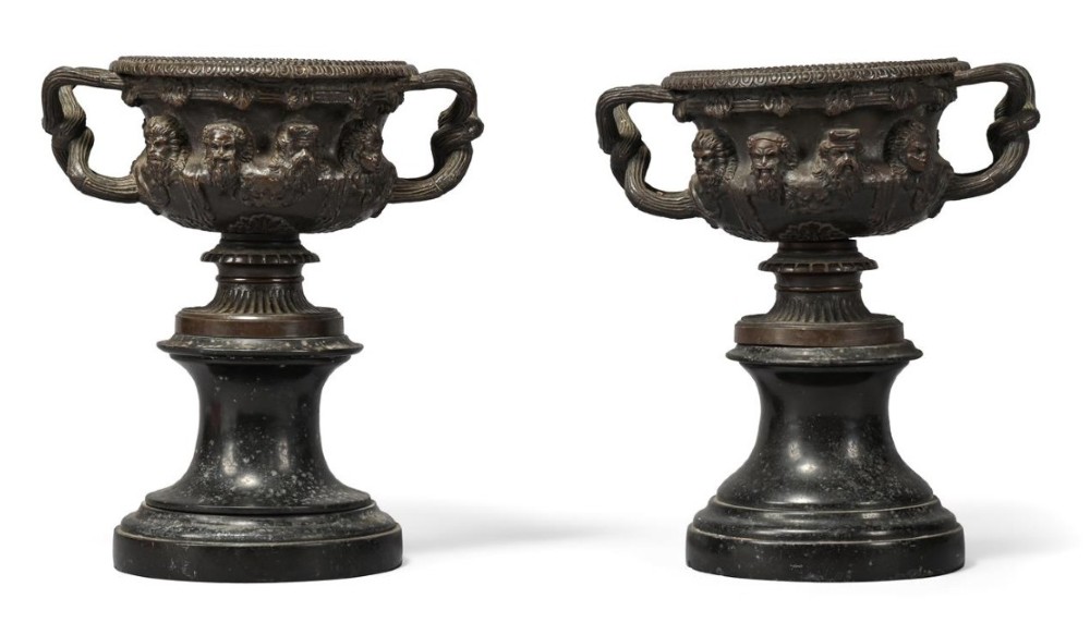 A pair of nineteenth-century patinated bronze Warwick vases with classical relief masks and woven handles, resting on black marble socles. View III