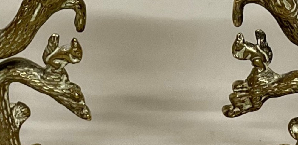 A pair of Regency gilt bronze candlesticks cast in the form of tree trunks with squirrels among the branches supporting campana sconces on square bases. View IV