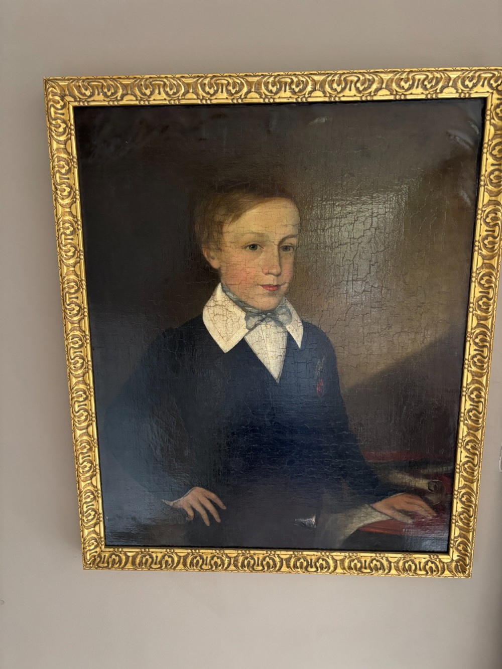 An antique oil portrait depicting a young male scholar in a dark blue coat and white collar, set in a gilded ornate frame. View II