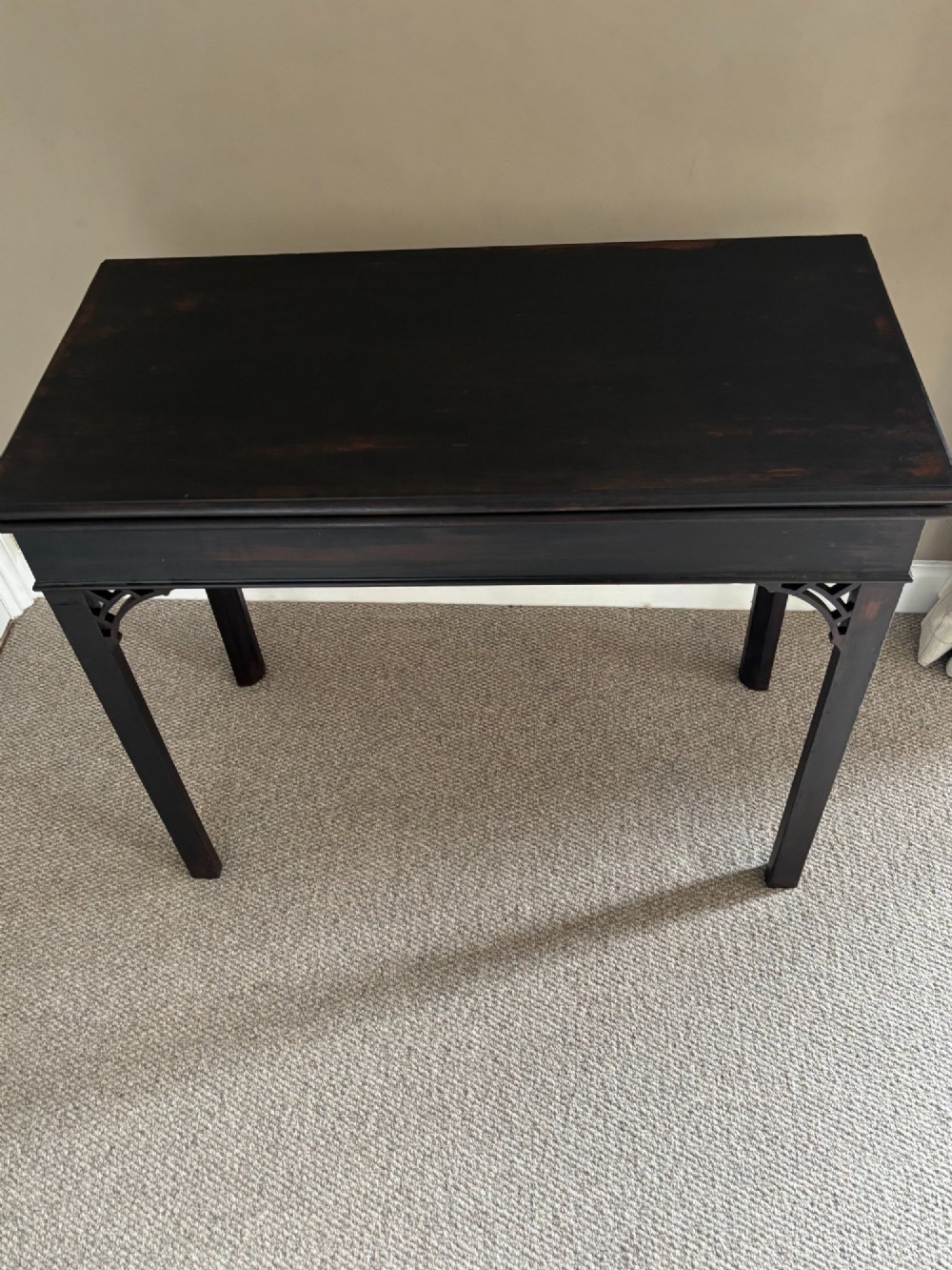 An 18th-century Chippendale mahogany card table with a rectangular fold-over top, pierced fretwork corner brackets, and straight square legs.