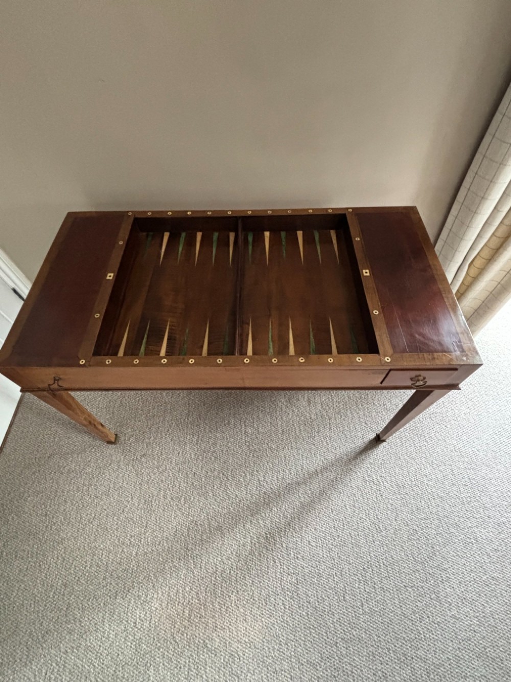 A French Empire mahogany tric-trac games table featuring a sunken central backgammon board with inlaid points and brass eyelets around the border. View III