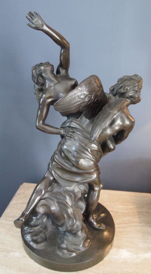 fig 1. A nineteenth-century dark patinated bronze sculpture depicting a winged male classical figure carrying a draped female figure on a circular base.
