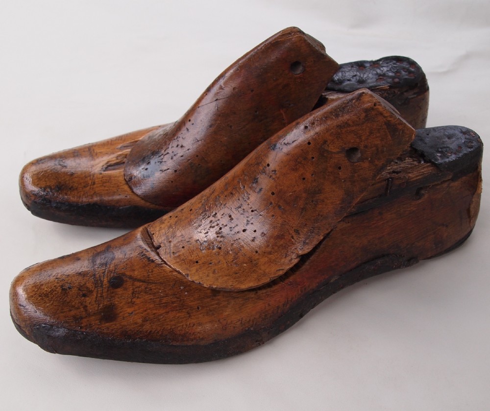 A pair of late 19th-century carved beechwood gents shoe lasts with a warm brown patinated finish and visible cobbler pin marks. View II