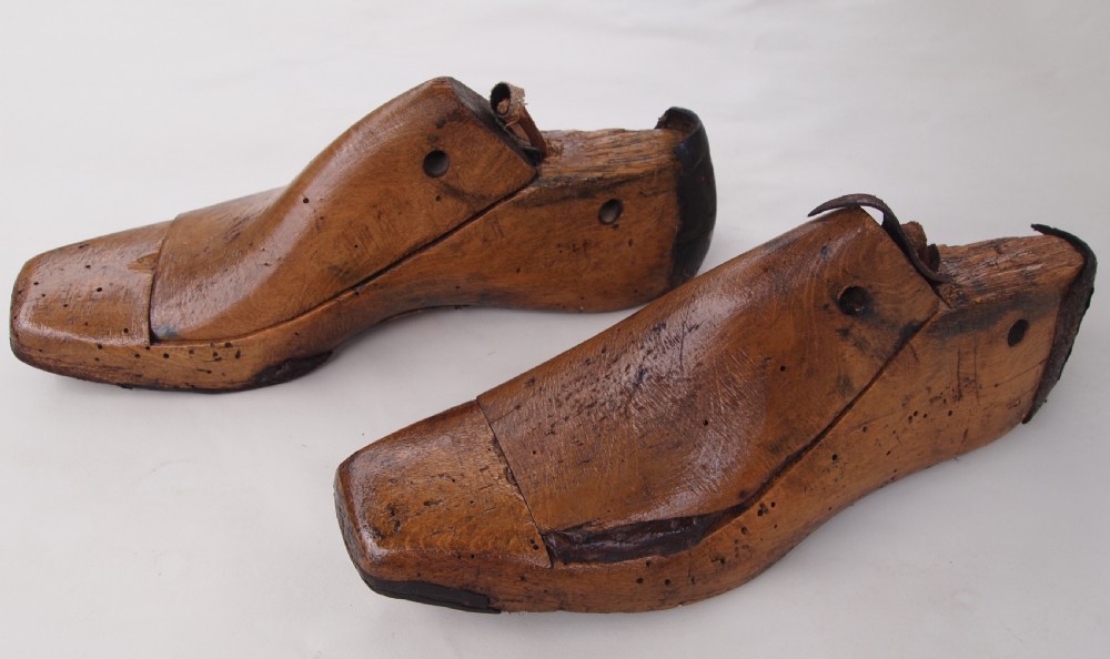 A pair of late 19th-century carved beechwood ladies shoe lasts featuring a warm brown patina and leather pull tabs.