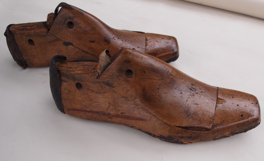 A pair of late 19th-century carved beechwood ladies shoe lasts featuring a warm brown patina and leather pull tabs. View II