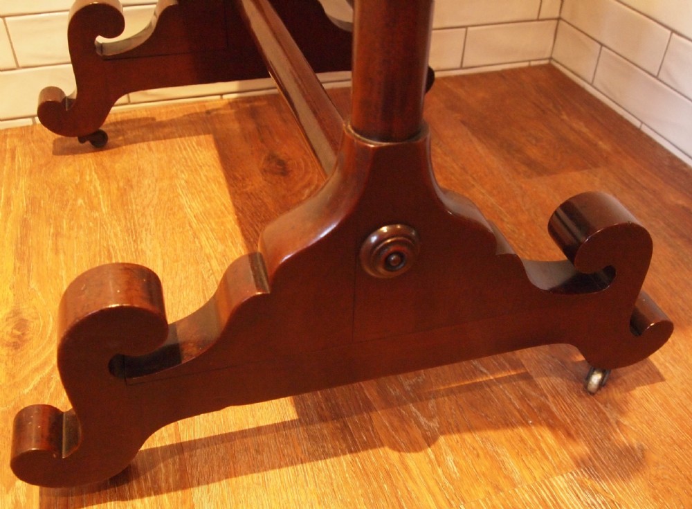 A Victorian mahogany cheval mirror featuring a rectangular pivoting frame supported by turned side uprights with adjustment knobs and carved scroll feet. View II