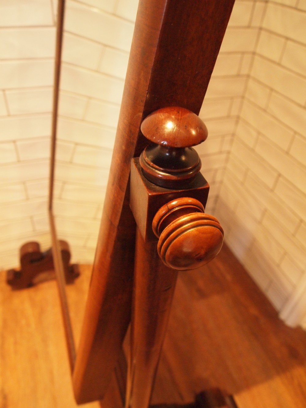 A Victorian mahogany cheval mirror featuring a rectangular pivoting frame supported by turned side uprights with adjustment knobs and carved scroll feet. View III