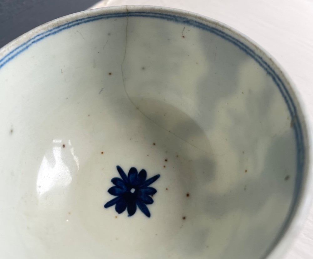 An 18th-century Lowestoft soft-paste porcelain tea bowl and saucer set decorated in underglaze cobalt blue with wavy bands and floral sprays. View IV