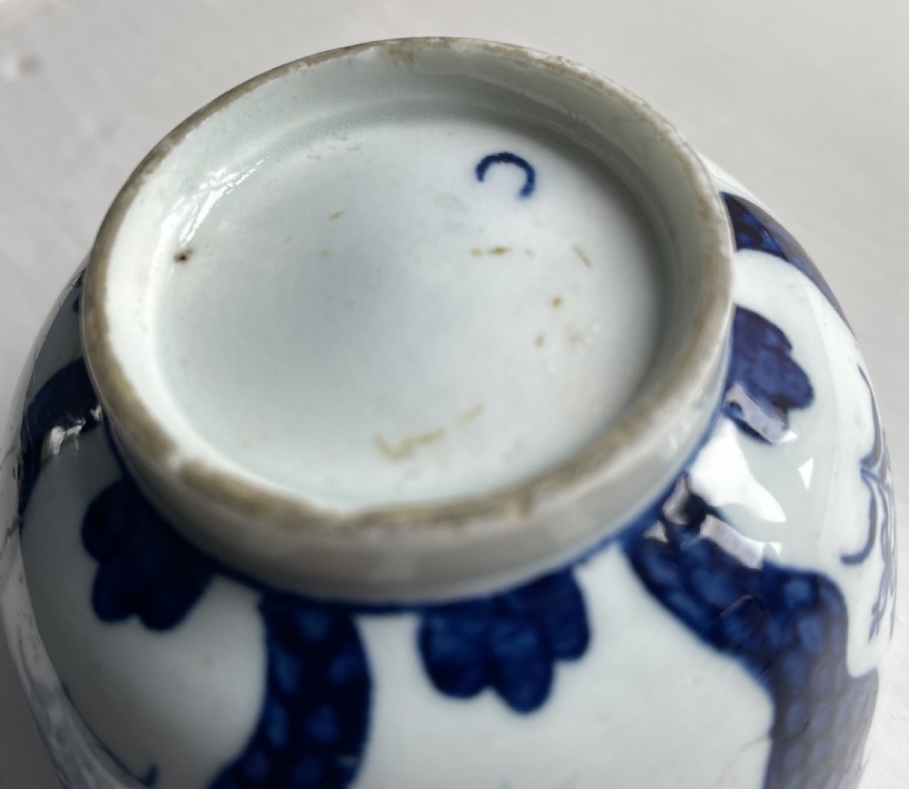 An 18th-century Lowestoft soft-paste porcelain tea bowl and saucer set decorated in underglaze cobalt blue with wavy bands and floral sprays. View V