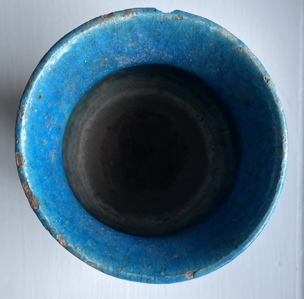 A turquoise glazed ceramic vessel with a flared rim, painted black geometric markings, and fine surface craquelure. View II