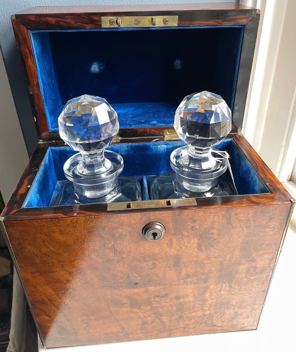 A closed rectangular burr walnut decanter box featuring thin brass trim around the outer edges and a circular brass keyhole escutcheon. View II
