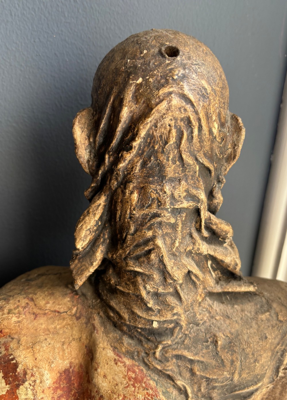 A 17th-century carved wooden figure of Christ with visible remnants of painted polychrome finish, draped robe, and detailed bearded facial features. View III