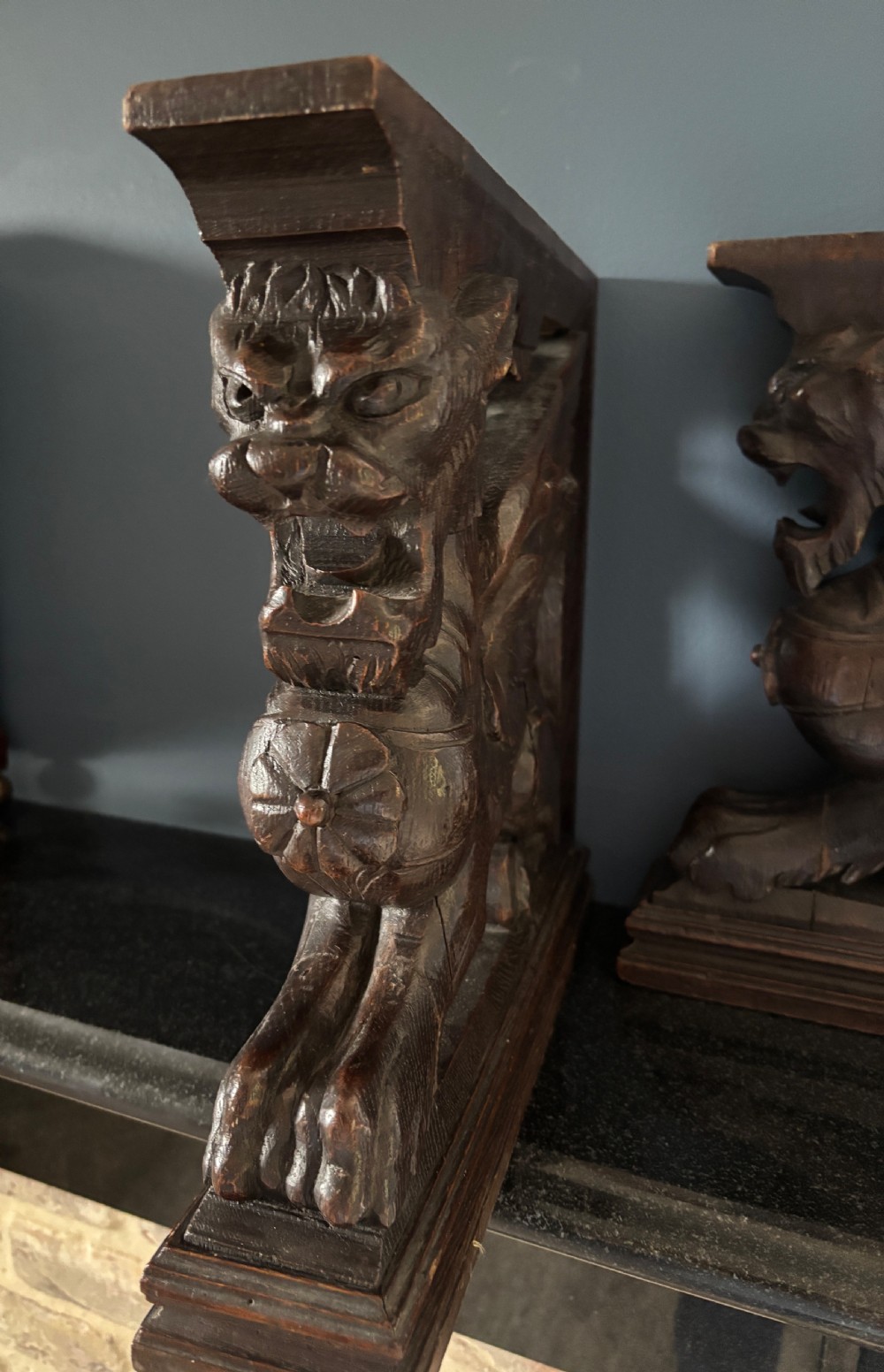 A facing pair of 19th-century carved dark oak panels depicting winged griffins set within rectangular timber frames. View III