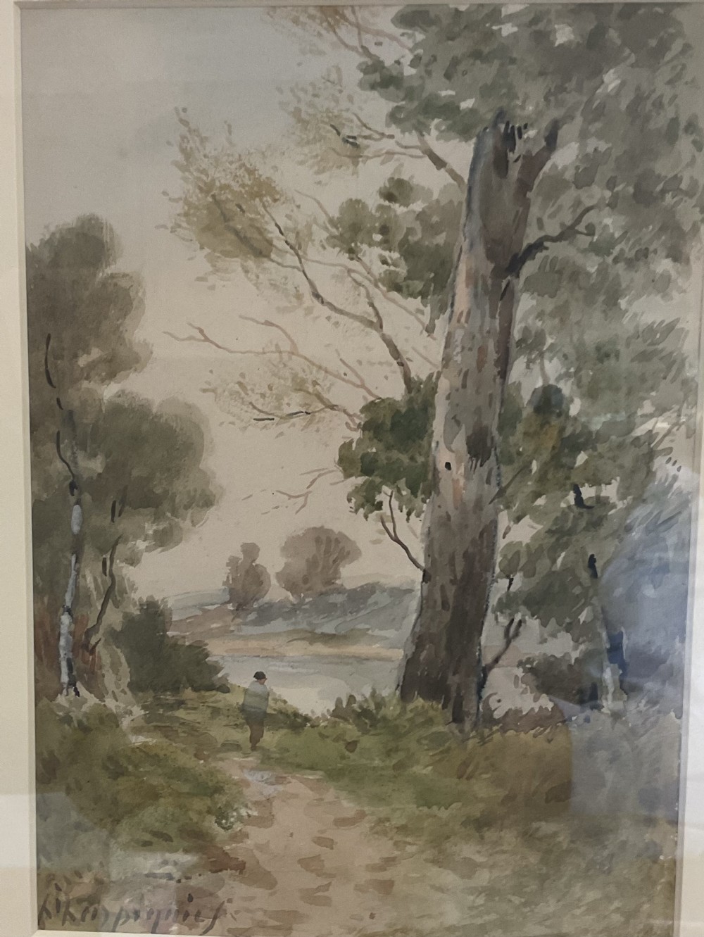 A watercolour landscape depiction of a woodland dirt path with a large tree trunk and a figure walking near water under a overcast sky.