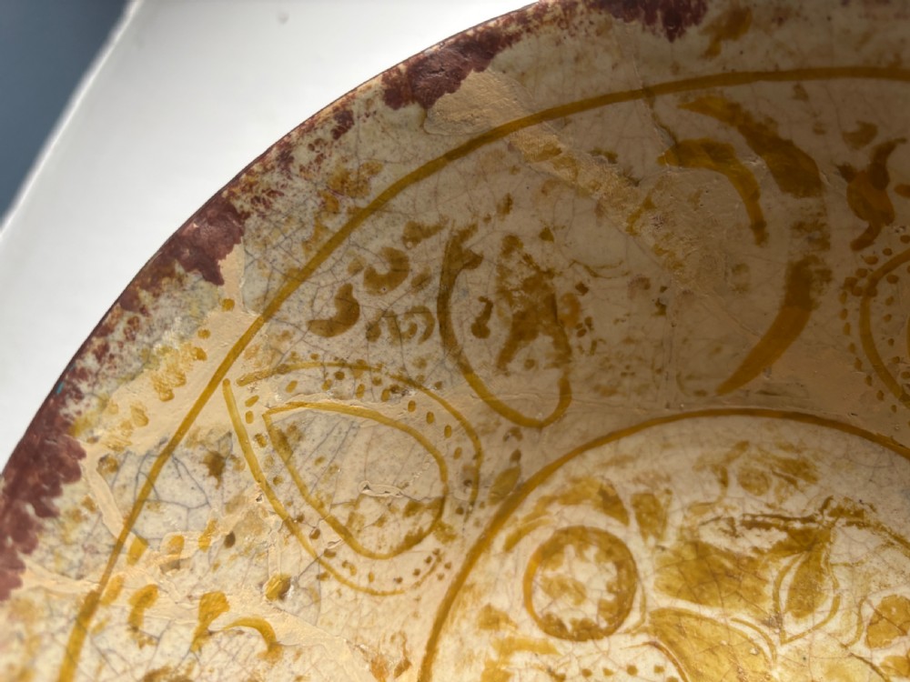 A round antique Persian ceramic footed bowl featuring golden-ochre lustre painted motifs and geometric borders on a craquelure off-white glaze. View II