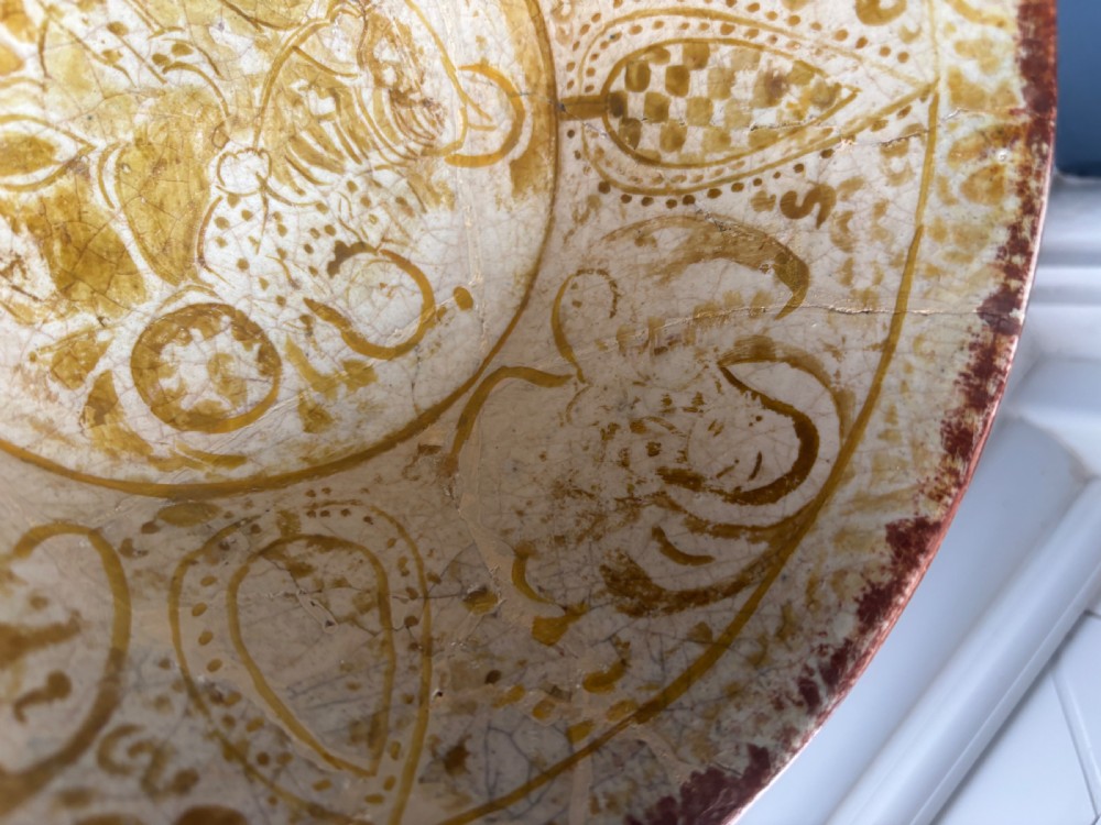 A round antique Persian ceramic footed bowl featuring golden-ochre lustre painted motifs and geometric borders on a craquelure off-white glaze. View IV
