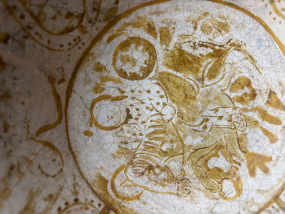 A round antique Persian ceramic footed bowl featuring golden-ochre lustre painted motifs and geometric borders on a craquelure off-white glaze. View V