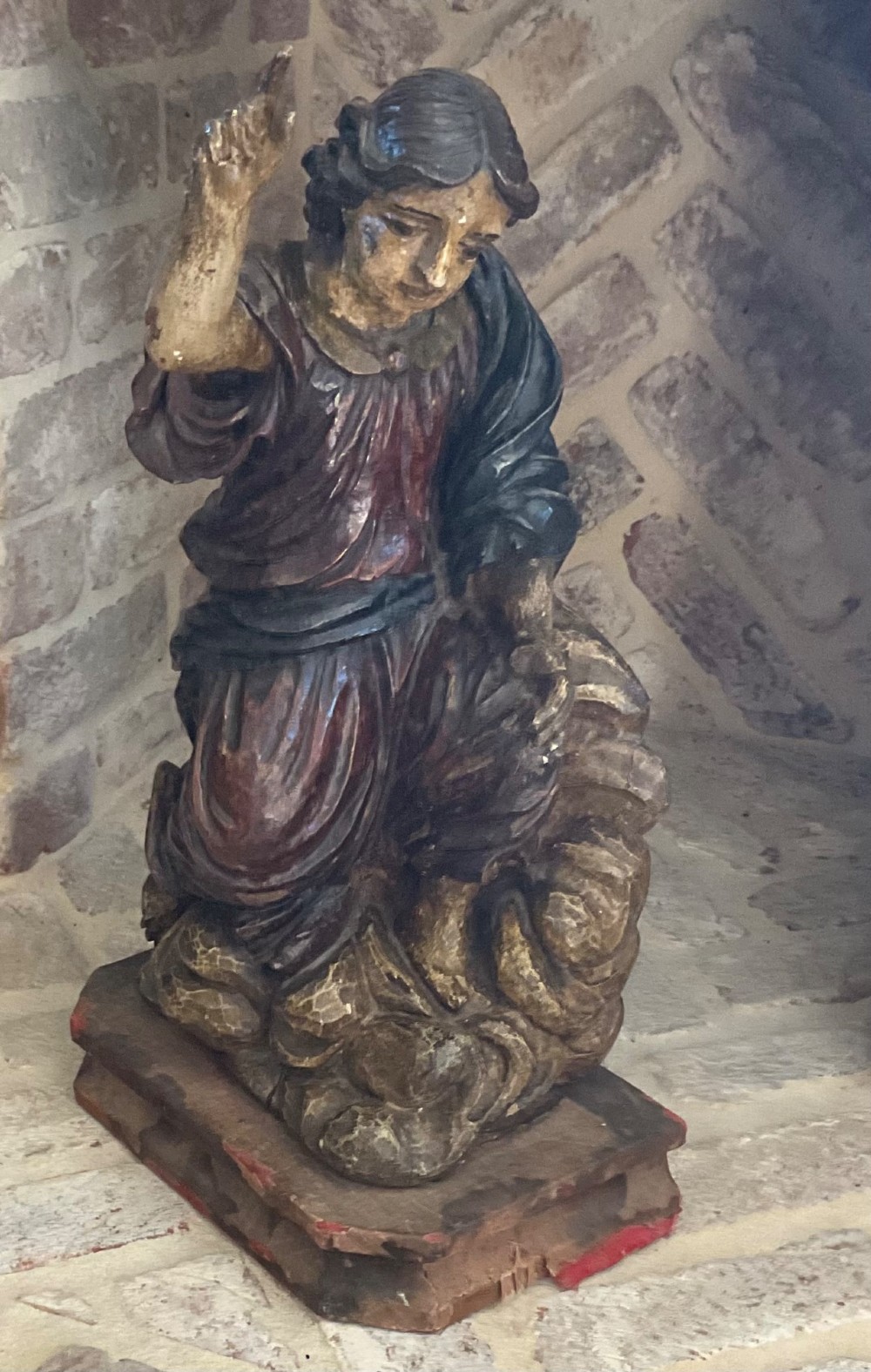 A 17th-century Italian carved polychrome wooden figure of Saint John the Baptist with raised finger and draped robes set upon a carved plinth. View II