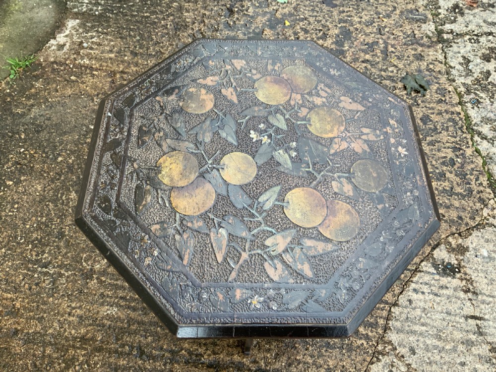 An octagonal dark wood Arts and Crafts occasional table featuring hand-painted fruit motifs on the top surface and lower tier. View II