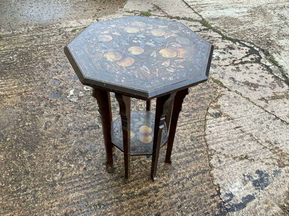 An octagonal dark wood Arts and Crafts occasional table featuring hand-painted fruit motifs on the top surface and lower tier. View III